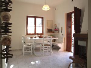 a dining room with a white table and chairs at Apartment- Rosa 4+2 in Sassetta