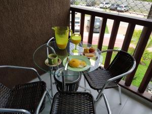 uma mesa de vidro com um prato de comida numa varanda em vemproCUPEPORTODEGALINHAS Casal ou Família no melhor apartamento de Porto de Galinhas em Porto de Galinhas