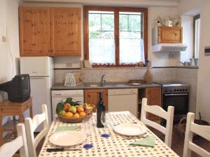 een keuken met een tafel en een fruitschaal bij Peonia 6 pax in Sassetta