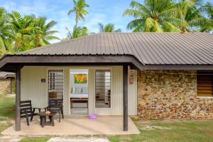 - un bâtiment avec une terrasse dotée d'une table et de chaises dans l'établissement Plantation Island Resort, à Malolo Lailai
