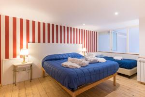 ナポリにあるResidenza Realeの赤と白のストライプを用いた客室内のベッド2台