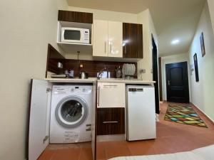 a kitchen with a washing machine and a microwave at Special Chalets in Porto South Beach families in Ain Sokhna