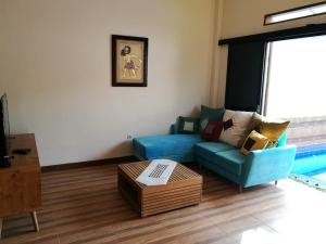 a living room with a blue couch and a coffee table at Jogja City Residence in Yogyakarta