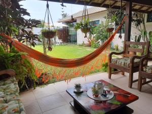 eine Hängematte inmitten einer Terrasse in der Unterkunft Casa na Praia do Foguete in Cabo Frio