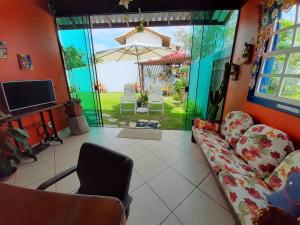 a living room with a couch and an umbrella at Casa na Praia do Foguete in Cabo Frio