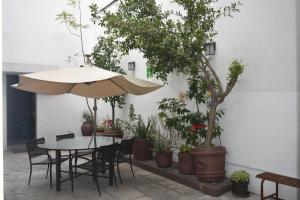 a table and chairs with an umbrella and potted plants at Hotel Río Puebla Centro in Puebla