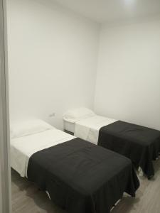 two beds in a room with black and white at Brazan Holidays in Corralejo