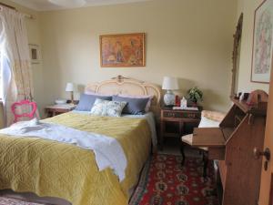 a bedroom with a bed and a desk and a piano at Redwood Valley B & B in Richmond