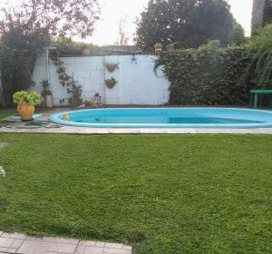 a small blue swimming pool in a yard at La Vilma Hospedaje Familiar in Paganini