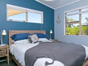 um quarto azul com uma cama e 2 janelas em Taruna - Tauranga Taupo Holiday Home em Kuratau