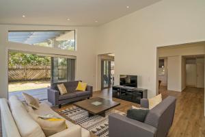 a living room with a couch and a table at Matarangi Marvel - Matarangi Holiday Home in Matarangi