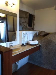 ein Bad mit einem Waschbecken und einem Spiegel in der Unterkunft La Roca House in Praia do Rosa