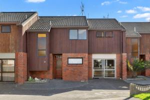 a large brick house with at Downtown Mountview - Mt Maunganui Holiday Home in Mount Maunganui
