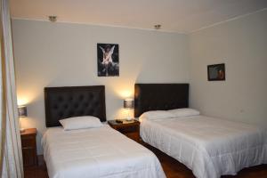 利馬的住宿－Casablanca Lima，配有白色床单的客房内的两张床