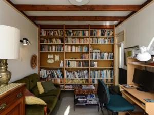een woonkamer met boekenplanken gevuld met boeken bij Jacaranda Lodge - Napier Hill Holiday Home in Napier