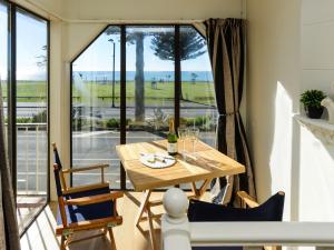 a dining room with a table and a large window at Marine Parade Magic - Napier Holiday Home in Napier
