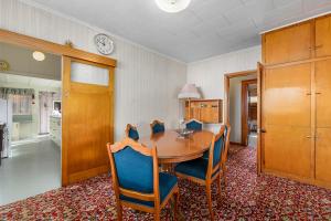 a dining room table with chairs and a clock on the wall at Leica Stay - Napier Holiday Home in Napier +12 photos