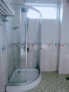 y baño con ducha y puerta de cristal. en Hoang Dat Hotel en Ðồng Hới