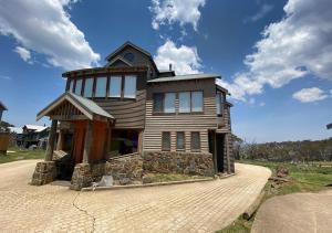 a large wooden house on top of a driveway at Camelot in Dinner Plain