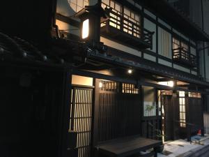 un edificio con un banco delante de él por la noche en 京ﾉ家 五条西洞院 en Kioto