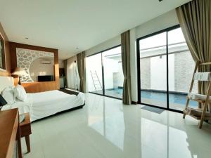 een grote slaapkamer met een bed en een groot raam bij The Vista Pool Villa in Kanchanaburi