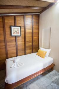 Schlafzimmer mit einem weißen Bett und Holzwänden in der Unterkunft 100 Islands Resort & Spa in Surat Thani