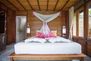 una camera con un letto bianco a baldacchino di 100 Islands Resort & Spa a Suratthani