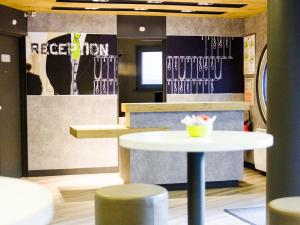 a restaurant with a white table and stools at ibis budget Angoulême Centre in Angoulême