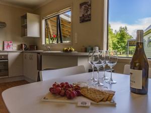 a table with wine glasses and a plate of food at Escape on Alpine - Ohakune Holiday Home in Ohakune