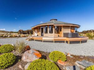 a large wooden house in a field with bushes at Heavenly Spa Views - Ohakune Holiday Home in Ohakune