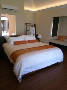 a bedroom with a large bed with white sheets and orange pillows at Sea Star Resort Semporna in Semporna