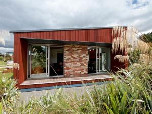 una casa roja con una gran ventana en el lateral. en Stargazer - Ohakune Holiday Home, en Ohakune