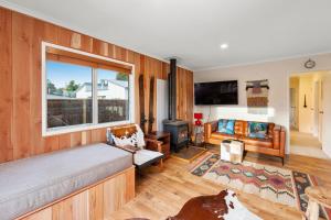 uma sala de estar com uma cama e uma janela em The Purple House - Ohakune Home with Spa Pool em Ohakune