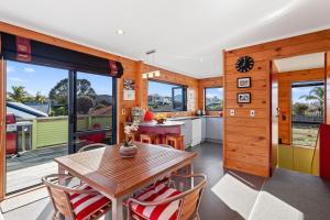 a kitchen and dining room with a table and chairs at Ohope Sunshine Escape - Ohope Holiday Home in Ohope Beach