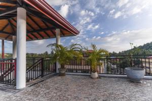 a balcony with a black fence and palm trees at Maple Place in Unawatuna