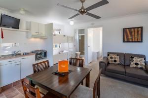 eine Küche und ein Wohnzimmer mit einem Tisch und einem Sofa in der Unterkunft Ingenia Holidays Kingscliff in Chinderah
