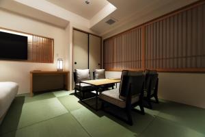 東京にあるプロスタイル旅館 東京浅草のテーブルと椅子、テレビが備わるホテルルームです。