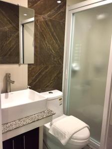 y baño con lavabo, aseo y ducha. en MAISON HOTEL, en Ciudad de Cauayán