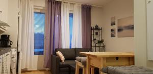 a living room with a chair and a table and window at Apartment in City - Antinkatu in Pori