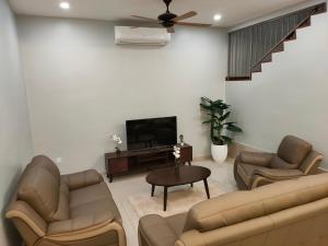 Il comprend un salon avec des canapés et une télévision à écran plat. dans l'établissement 58 Kota Laksamana - Near Jonker Street for 10 to 15 Pax, à Malacca