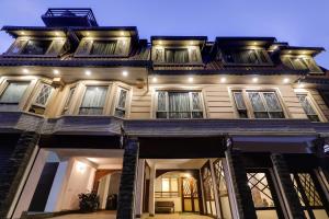 a large house with lights on top of it at Summit Hermon Hotel & Spa in Darjeeling