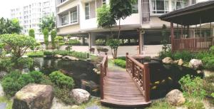 a bridge over a pond in front of a building at Furusato Midori Green- Tmn Mount Austin at Johor Bahru in Johor Bahru