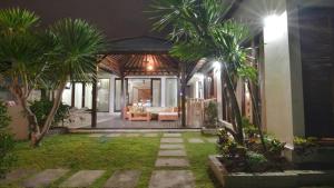 a house with palm trees in the yard at night at Villa Hibiscus in Sanur