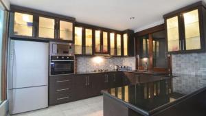 a kitchen with brown cabinets and a white refrigerator at Villa Hibiscus in Sanur