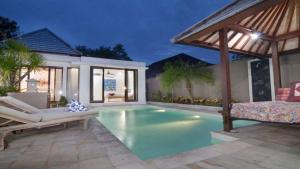 a swimming pool in a villa with a patio at Villa Hibiscus in Sanur