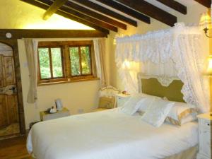 1 dormitorio con 1 cama blanca con dosel en The Old Carthouse, en Bridgwater