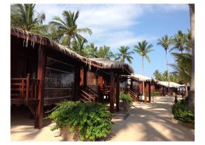 a row of buildings with palm trees in the background at Nilaveli Beach Resort - Level 1 Certified in Nilaveli