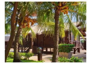 two palm trees in front of a house at Nilaveli Beach Resort - Level 1 Certified in Nilaveli