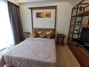 ein Hotelzimmer mit einem Bett und einem TV in der Unterkunft AK Homes in Kuantan