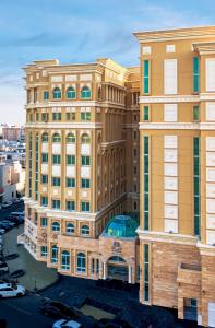 duży żółty budynek przed ulicą w obiekcie Al Diyafa Furnished Suites w mieście Doha